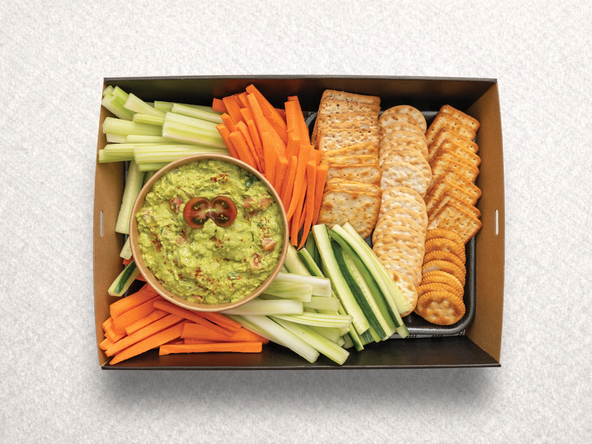 Guacamole dip with veggie stick sand crackers Guacamole dip with veggie stick sand crackers